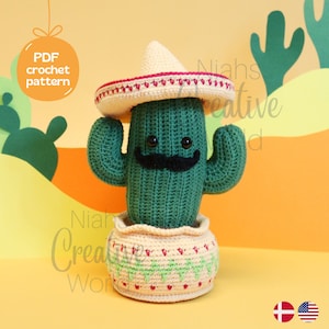 Peut inclure: Un cactus en crochet portant un sombrero, avec une moustache et un pot. Le cactus est vert, le sombrero est crème et rouge, la moustache est noire et le pot est crème avec des accents verts et rouges. L'arrière-plan est une scène de désert jaune et orange.