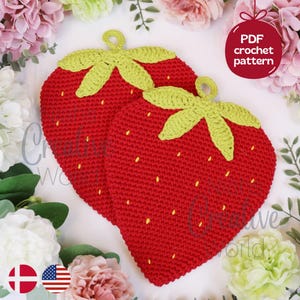 May include: Two strawberry-shaped crochet potholders featuring red yarn bodies with yellow embroidered seeds and light green crocheted leaves at the top. Each piece includes a small loop for hanging. Text on the image reads PDF crochet pattern.