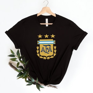 May include: Black t-shirt with a gold and blue crest featuring the letters "AFA" and three stars.