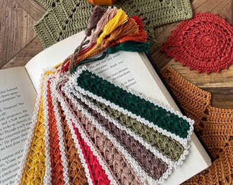Könnte beinhalten: Eine Sammlung rechteckiger Häkel-Lesezeichen in verschiedenen Farben, darunter Dunkelgrün, Braun, Beige, Rot, Orange und Gelb. Jedes Lesezeichen hat einen weißen Häkelrand und eine farblich passende Quaste an der oberen Kante.