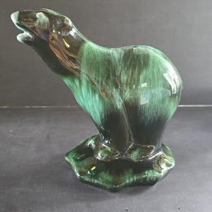 May include: A ceramic polar bear figurine in shades of green and black. The bear is standing on a base, with its head tilted back and mouth open. The glossy finish gives it a vintage look.