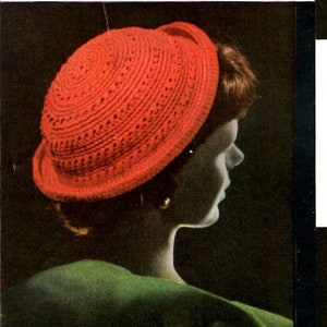 May include: A red crocheted hat with a wide brim. The hat is made with a simple stitch pattern and has a slightly rounded crown.
