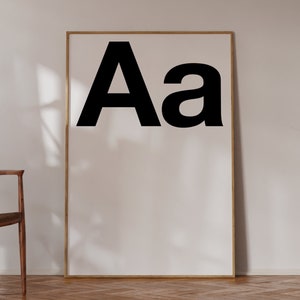 May include: A framed print with the letters "Aa" in black on a white background.