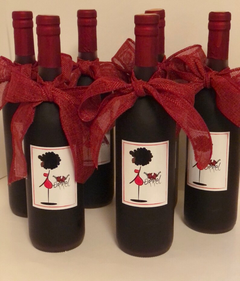 May include: Six bottles of wine with red ribbon bows and personalized labels featuring a cartoon woman with an afro and the word "Orrel".