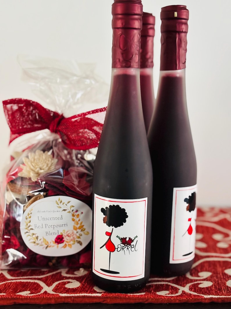May include: Three glass bottles of red wine with a black and white label featuring a cartoon woman in a red dress. The label also includes the word "Orrel".