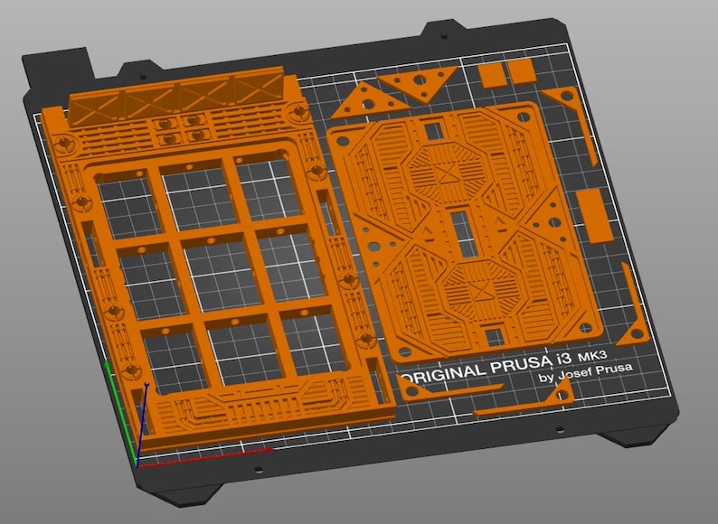 Peut inclure: Un plateau d'imprimante 3D orange avec un motif quadrill&eacute; et diverses formes d&eacute;coup&eacute;es. Le texte "ORIGINAL PRUSA i3 MK3 by Josef Prusa" est visible. Le plateau est rectangulaire avec un bord gris fonc&eacute;.