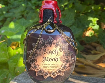 May include: A dark glass bottle with a red wax seal and a black gemstone pendant. The bottle is labeled "Black Blood" and says "Turns the drinker's blood poisonous when feasted on by monsters."
