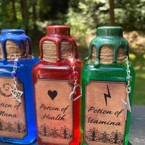 May include: Three glass bottles with cork stoppers and labels. The bottles are filled with blue, red, and green liquid. The labels read "Potion of Mana", "Potion of Health", and "Potion of Stamina".