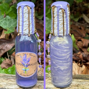 K&ouml;nnte beinhalten: Eine kleine Glasflasche mit einer violetten Fl&uuml;ssigkeit und goldenen Akzenten. Die Flasche hat ein Etikett mit der Aufschrift "Simple. Yet Powerful. SLEEPING DRAUGHT. Once the fantastical...