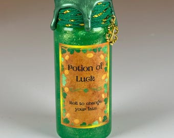May include: A green glass bottle with a gold glitter finish and a green wax seal. The bottle has a label that reads "Potion of Luck" and "Roll to change your fate".