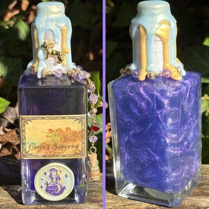 May include: A glass bottle with a purple liquid inside. The bottle has a blue and gold wax seal on the top and a label that reads "Circe's Sorcery".