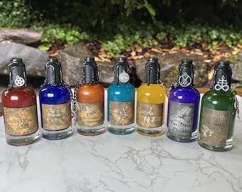 May include: Seven small glass bottles with black lids and silver charms. Each bottle contains a different colored liquid and has a label with a different name and design. The names on the labels are "Satan's Wrath", "Asmodeus's Gluttony", "Beelzebub's Lust", "Belial's Greed", "Mammon's Gluttony", "Lucifer's Pride", and "Leviathan's Envy".