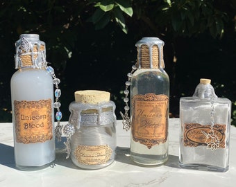 May include: Three glass bottles with silver lids and labels that say "Unicorn Blood", "Unicorn Water", and "Unicorn Hair". The bottles are filled with a white liquid and have a silver chain attached to the lid.