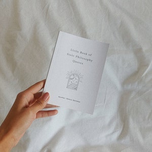 May include: A white booklet with the title "Little Book of Stoic Philosophy Quotes" and a black and white illustration of a window with stars and a staircase. The text "Aurelius, Seneca, Epictetus" is printed at the bottom of the booklet.