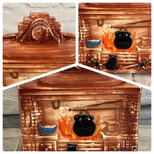 Puede incluir: Una jarra de galletas de cerámica con forma de chimenea con un gato negro, un caldero y llamas. La jarra tiene un patrón de ladrillo marrón y blanco y un techo marrón con una esfera de reloj.