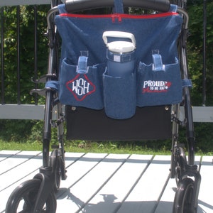 May include: A black walker with a denim bag attached. The bag has a red zipper and a white water bottle inside. The bag has two pockets with embroidered text, one that says "WSH" and the other that says "Proud to be an American".