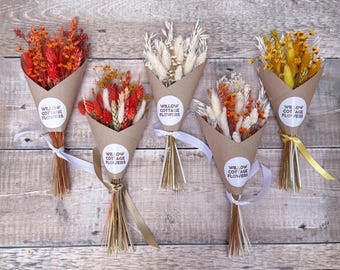 Könnte beinhalten: Fünf kleine Trockenblumensträuße, eingewickelt in braune Papierkegel. Jeder Kegel hat einen weißen, runden Aufkleber mit dem Text Willow Cottage Flowers. Die Sträuße bestehen aus verschiedenen getrockneten Gräsern und Blumen in Orange, Rot, Weiß und Gelb.
