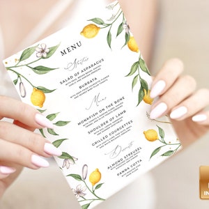 May include: A wedding menu card with a lemon and floral design. The menu includes Salad of Asparagus with Burrata, Monkfish on the Bone, Shoulder of Lamb, Grilled Courgettes, Almond Streusel, and Panna Cotta.