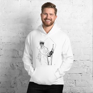Puede incluir: Sudadera con capucha blanca con una ilustración en blanco y negro de una persona con gafas y sosteniendo bastones de esquí. La ilustración está dentro de un diamante.