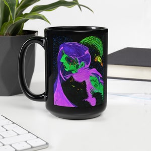 May include: Black coffee mug with a graphic of a purple and green figure with a black cat. The figure has a green face with a black eye and a black nose.