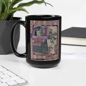 May include: Black ceramic mug with a colorful illustration of a fantastical scene featuring a pink and purple creature, a green figure, and a building made of blocks. The illustration is surrounded by a pink and white striped border.