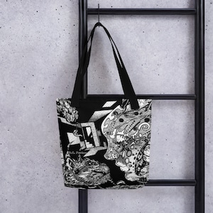 May include: Black and white tote bag with a graphic design featuring a stylized face with intricate details. The text "B.C. Foster" is visible on the bag.