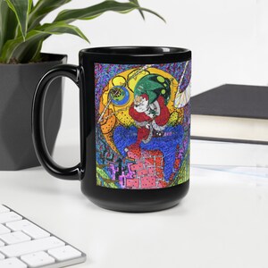 May include: Black ceramic mug with a colorful illustration of Santa Claus climbing down a chimney. The illustration features a bright blue sky, green and yellow trees, and a red brick chimney.