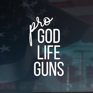 Pode incluir: Um adesivo de vinil branco com o texto "pro GOD LIFE GUNS" em um fundo de bandeira americana azul e branco.