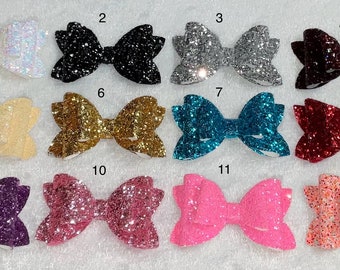 Puede incluir: Doce lazos para el pelo de purpurina en varios colores, incluyendo blanco, negro, plateado, rojo, amarillo, dorado, azul verdoso, burdeos, morado, rosa y naranja. Cada lazo está numerado del 1 al 12.