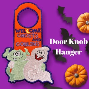 Op de afbeelding: Oranje deurhanger met de tekst "Welcome Ghosts and Goblins" en twee cartoon-geesten, een groene en een witte.