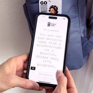 Peut inclure: Un smartphone affichant un site web avec le texte : You are one bad decision away from a breakthrough&mdash;or a burrito. Either way, it's progress. Au-dessus du t&eacute;l&eacute;phone, une &eacute;tiquette blanche porte le texte GO, du code binaire et une illustration.