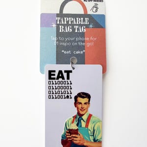 Peut inclure: Une &eacute;tiquette de sac rectangulaire blanche avec le mot EAT en noir, du code binaire et une illustration r&eacute;tro d'une personne en chemise bleue et tablier rouge tenant un cupcake. L'&eacute;tiquette est fix&eacute;e sur une carte color&eacute;e avec le texte TAPPABLE BAG TAG.
