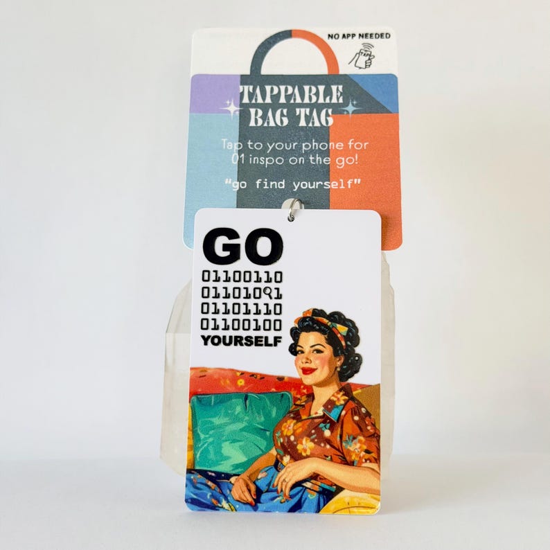 Peut inclure: Une &eacute;tiquette de sac rectangulaire blanche avec le texte GO, du code binaire et le mot YOURSELF au-dessus d'une illustration d'une personne en chemise &agrave; fleurs. L'&eacute;tiquette est fix&eacute;e sur une carte color&eacute;e avec le texte TAPPABLE BAG TAG et NO APP NEEDED.