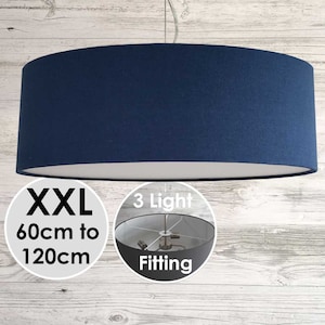 May include: A large, dark blue, drum-shaped lampshade with a 3-light fitting. The shade is 60cm to 120cm in diameter.  The lampshade is hanging from a ceiling.