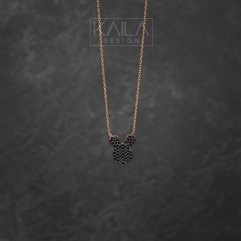 K&ouml;nnte beinhalten: Eine Halskette aus ros&eacute;goldener Kette mit einem schwarzen Zirkonia-Mickey-Mouse-Anh&auml;nger.