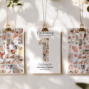 May include: Three photo collages of a baby's first year, suspended by gold clips. The center collage features the number "1" filled with baby photos, with text that reads "Celebrating The Wonderful Year of" and "Welcome to Olivia Wilson, 1st Birthday November 20, 2025."