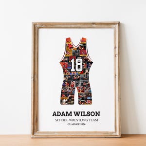 K&ouml;nnte beinhalten: Gerahmter Druck mit einem Wrestling-Singlet-Design, gef&uuml;llt mit Actionfotos. Das Singlet hat die Nummer 18 in Wei&szlig;. Darunter stehen die Worte "ADAM WILSON", "SCHOOL WRESTLING TEAM" und "CLASS OF 2026". Der Rahmen ist hellbraun.