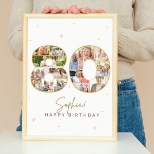 May include: A white photo collage in a wooden frame with a gold outline of the number 80. The collage is made up of photos of people. The text "Sophia! Happy Birthday" is written below the collage.