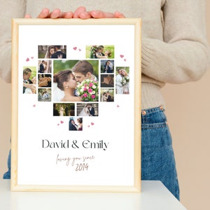 Op de afbeelding: Een ingelijste fotocollage in een licht houten lijst met een hartvormige opstelling van foto's van een stel. De tekst "David & Emily loving you since 2014" staat onder de foto's.