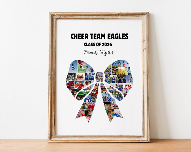 May include: Framed print featuring a bow-shaped collage of photos, with the text "CHEER TEAM EAGLES CLASS OF 2026" and a name. The frame is a light brown color, and the print is displayed on a wooden surface.