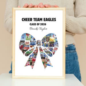 May include: A framed print with the text "CHEER TEAM EAGLES CLASS OF 2026" and the name "Brooke Taylor." The image features a bow-shaped collage of cheerleading photos. The frame is made of light-colored wood.