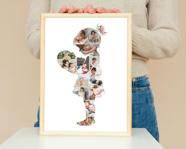 May include: A framed photo collage in the shape of a girl holding a heart. The heart and girl's silhouette are filled with multiple baby photos. The frame is light brown.
