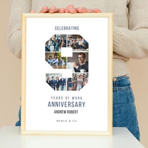 May include: A white framed poster with a collage of photos in the shape of the number nine. The text "Celebrating 9 Years of Work Anniversary Andrew Robert Merck & Co" is printed on the poster.