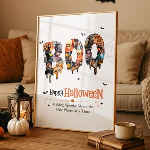 May include: A vertical rectangular poster in a thin gold frame featuring the word BOO in large, dripping letters filled with a collage of various Halloween-themed photos. Below, the text reads Happy Halloween and Making Spooky Memories, One Photo at a Time.