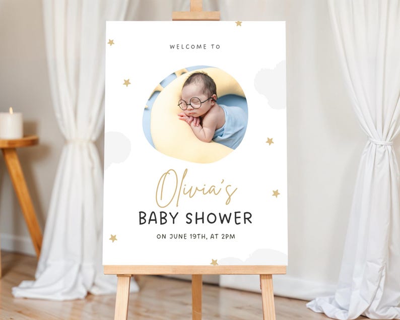K&ouml;nnte beinhalten: Willkommen zur Baby Shower von Olivia Schild mit wei&szlig;em Hintergrund, blauen und wei&szlig;en Wolken, goldenen Sternen und einem Foto eines Babys mit Brille, das auf einem gelben Halbmond schl&auml;ft.
