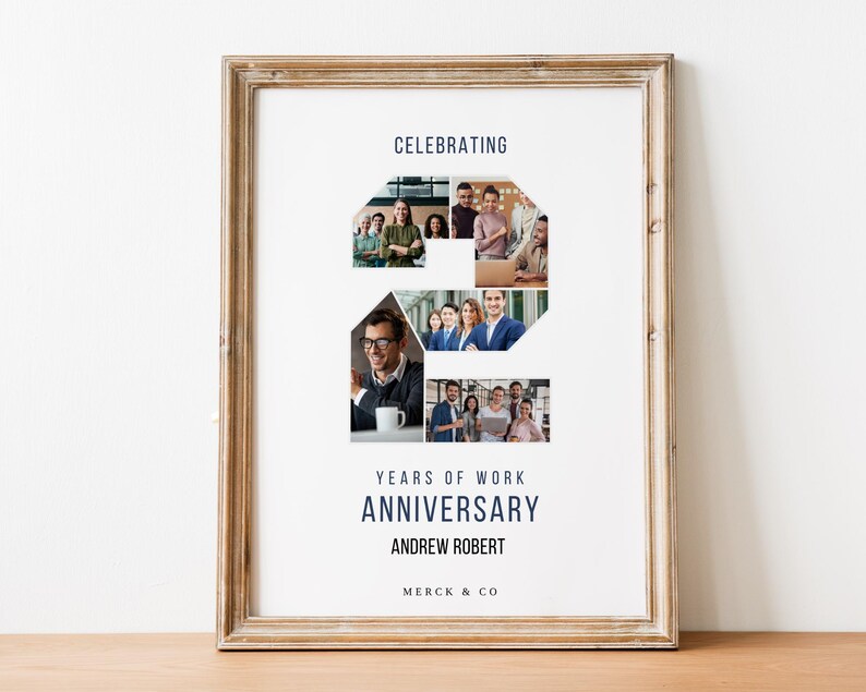 以下が含まれることがあります： アンドリュー・ロバートのMerck & Co.での2周年記念を祝う額装されたポスター。ポスターには、職場環境にいる人々の写真のコラージュが、数字の2の形に配置されています。