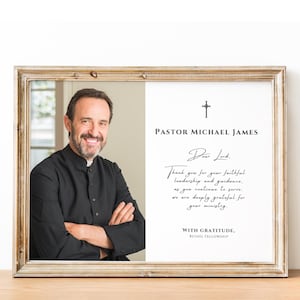 May include: Framed portrait of a man in a black clerical shirt, smiling with arms crossed. The right side of the frame has text: "PASTOR MICHAEL JAMES" and a handwritten message of gratitude. The frame has a gold finish.