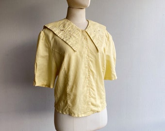 Vintage Bluse aus den 80ern in Pastell gelb, mit großem Kragen und Blumenstickerei, Größe M-L