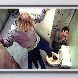 K&ouml;nnte beinhalten: Ein Mann in einer grauen Jacke und blauen Jeans steht &uuml;ber einer Toilette, w&auml;hrend ein anderer Mann auf dem Boden neben der Toilette sitzt und verzweifelt aussieht. Die Toilettensch&uuml;ssel ist mit Wasser gef&uuml;llt und der Fu&szlig; des Mannes befindet sich im Wasser.
