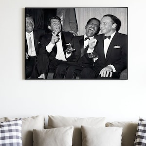 Puede incluir: Fotografía en blanco y negro de cuatro hombres con traje y pajarita riendo juntos. Los hombres están sentados y parecen disfrutar de la compañía del otro.